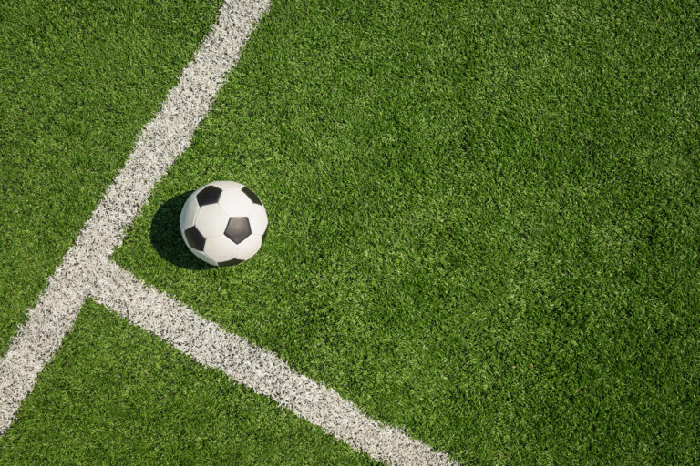 Soccer Ball on Green Grass Field with White Corner