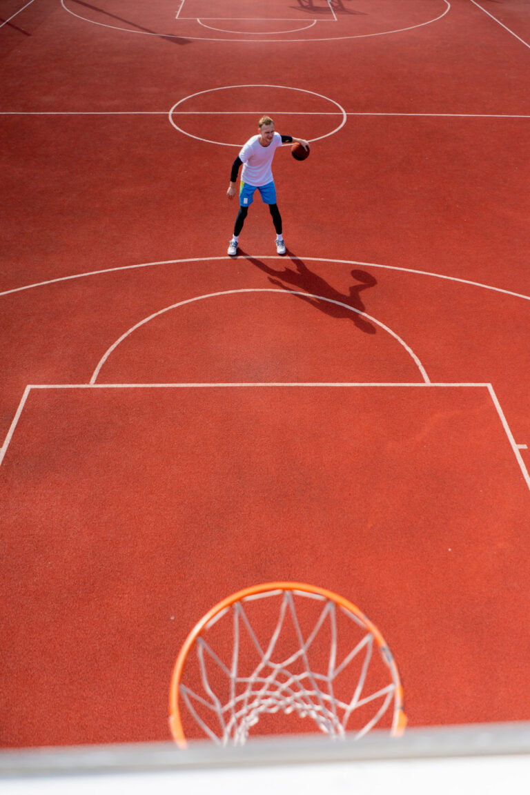 Close-up of basketball ring into which a tall guy basketball pla
