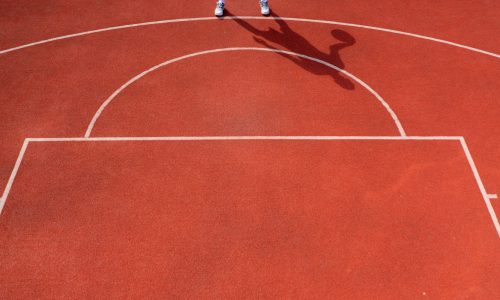 Close-up of basketball ring into which a tall guy basketball player throws the ball The concept of admiring the game of basketball
