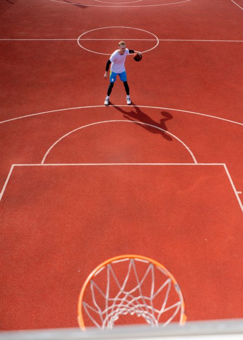 Close-up of basketball ring into which a tall guy basketball player throws the ball The concept of admiring the game of basketball